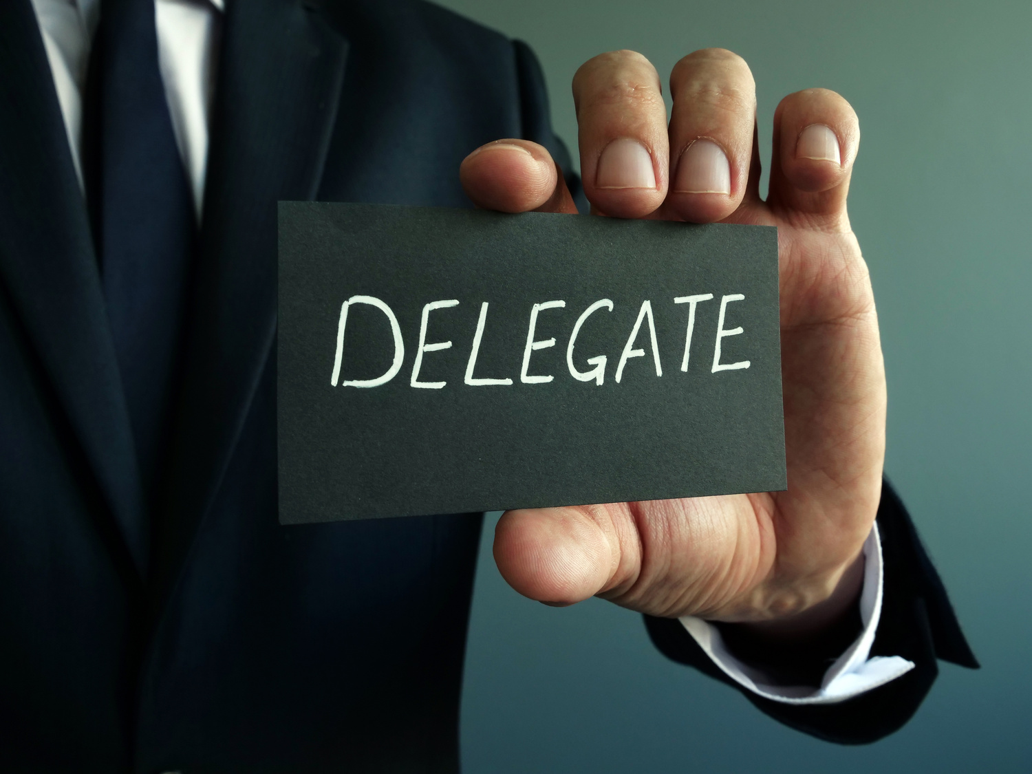 Delegate sign in the hands of a businessman. Delegation concept.